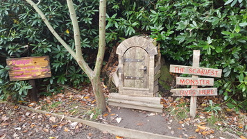 Monster trail. A wooden door for children to open with a sign saying 'The scariest monster lives here'