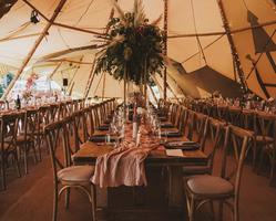 Tables laid out for a meal in the Tipi at Cannon Hall, decorated with linen, foliage and glasswear.