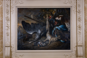 A painting depicting a hunting scene with a dead hare and bird. A hunting dog is in the background, along with a rifle and hunting accessories. The artwork is in an ornate, decorated frame with intricate patterns.
