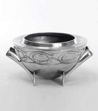 Silver bowl with a thick rim and two handles which also curve under to form the base. It has roses carved into it around the top.