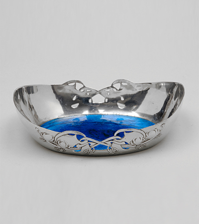 Shallow silver dish with geometric designs and a circular base of deep blue colour