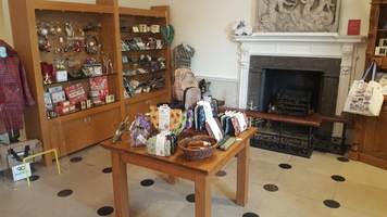 Museum shop showing gifts and retail displays beside a period fireplace