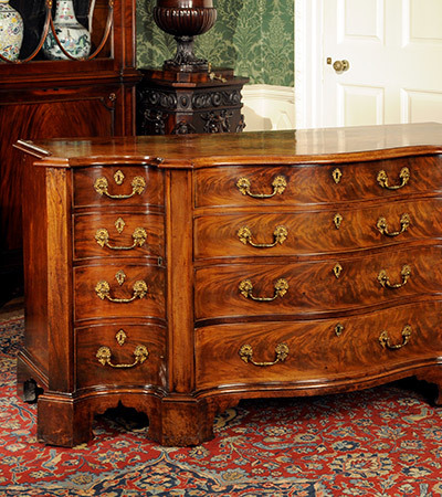 Wooden cabinet with four long draws in the middle and four shorter draws at the side. Each draw has gold looped handles and a keyhole to lock it.